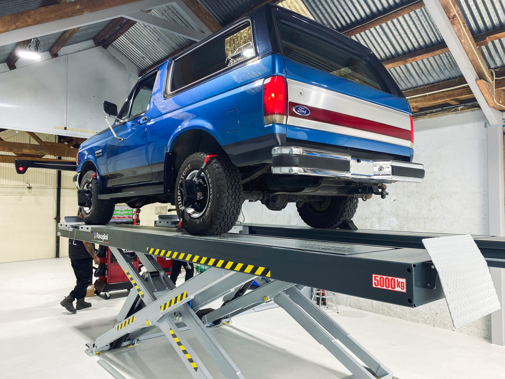 1987 Ford Bronco on Ravaglioli scissor lift in front of Hunter Engineering Elite wheel alignment machine at Dargaville Motors